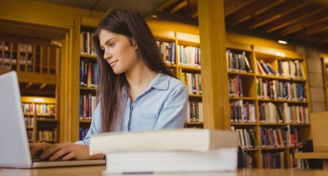 College student looking at computer in library