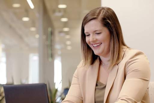 Woman smiling and working at computer