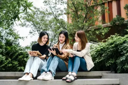 international students sitting on steps at university